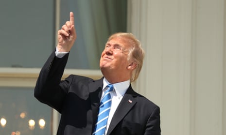 Trump points skyward before donning protective glasses to view the solar eclipse