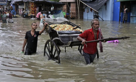 An Indian rickshaw puller makes his way through a flooded street in Calcutta on Sunday 2 August 2015.