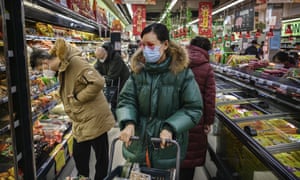 A woman wears a protective mask in a Beijing supermarket. The WHO has declared the coronavirus a global emergency.