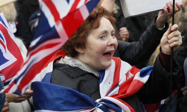Pro-Brexit demonstrators wave flags outside Parliament.