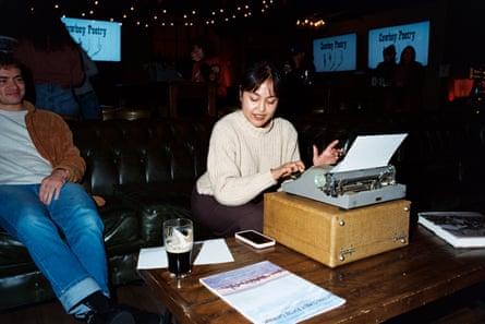 A woman writing on a typewriter in a bar