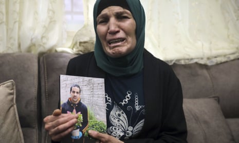 Rana, the mother of Iyad Halak, holds his photo.