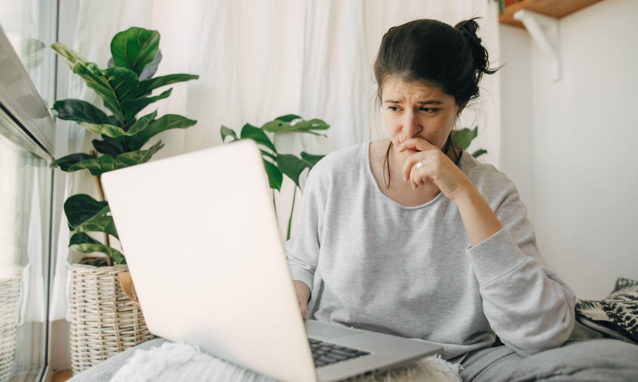 Woman with stressed expression on her face looking at an open laptop