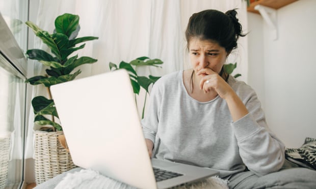 Woman looking at a laptop with worried expression