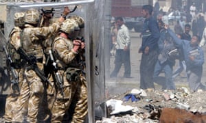 A youth hurls a rock at British soldiers during a violent protest in Basra in 2004.