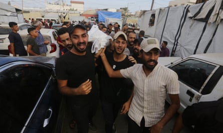 Relatives carry the bodies of their deceased loved ones wrapped in shrouds after an Israeli attack in Dair El-Balah, Gaza