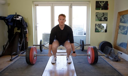 Greg Rutherford lifting weights in the gym at his home.