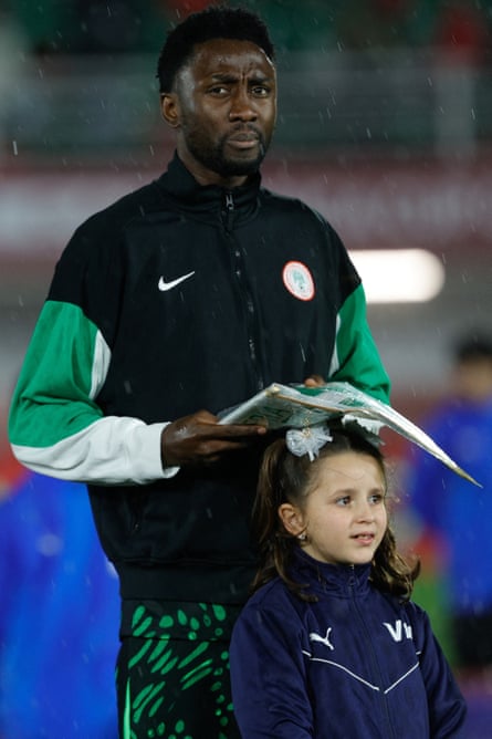Nigeria’s midfielder Wilfred Ndidi shields a mascot from the rain before the Afcon last-16 tie against Mozambique