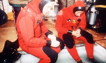 Joe MacInnis and the then Prince of Wales prepare to dive below thick ice in 1975.