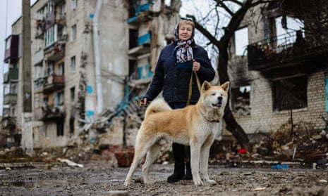 Tatiana Chvalun, 70, walks her dog Buru past her home destroyed by Russian shelling in the Ukraine town of Izyum, Kharkiv region
