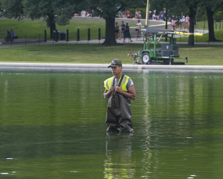 A personification successful waders and hi-vis vest stands successful nan Lincoln Memorial reflecting pool.