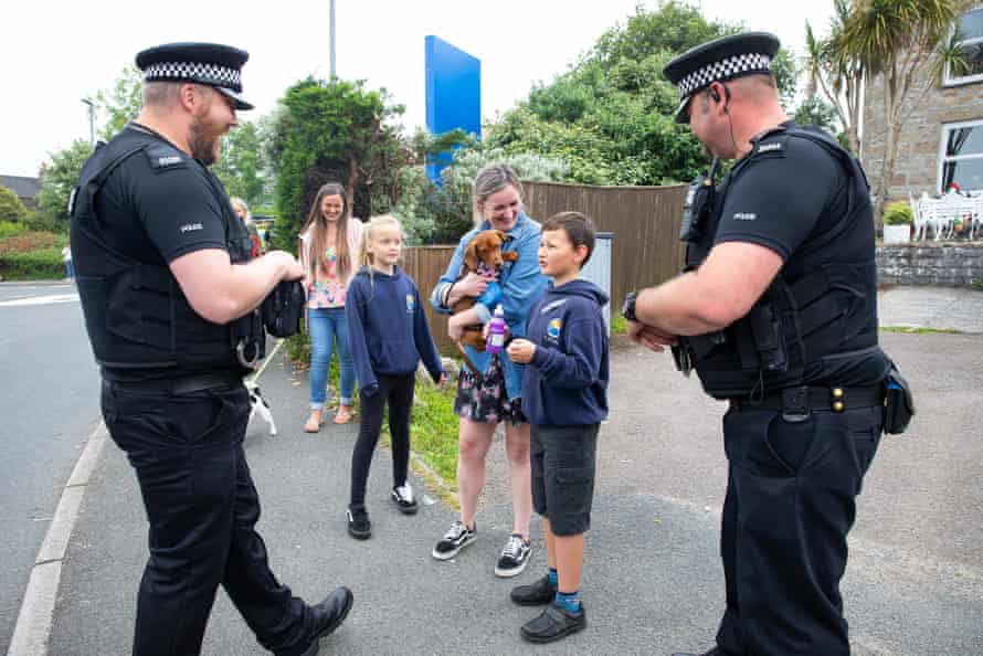 Policemen talking to children along the main road through Carbis Bay.
