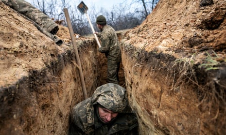 A Ukrainian infantryman with the 28th Brigade takes cover in a partially dug trench along the frontline outside Bakhmut.