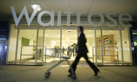 Waitrose store front with woman pushing a trolley past it