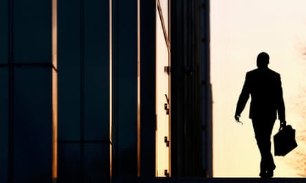 A silhouette of a man in a suit outside a building