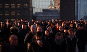 Commuters walk across London Bridge at sunrise in London, January 2018.