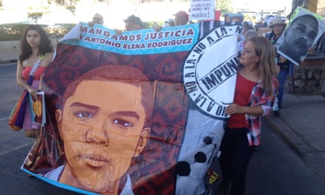 Araceli Rodríguez, the mother of José Antonio Elena Rodríguez holds a banner with her son’s image as part of a march demanding a retrial of the agent who shot her son.