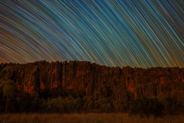 time lapse photo of stars against mountain range