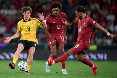 Lewis Koumas is challenged by Portugal’s Bruno Fernandes and Renato Veiga.