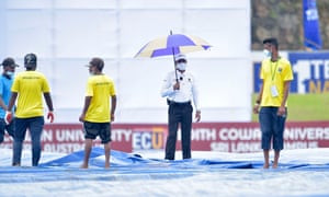 Ground staff cover the pitch on the second day of the first Test.