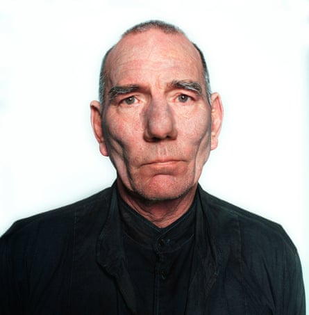 A man with cropped grey hair wearing a black top