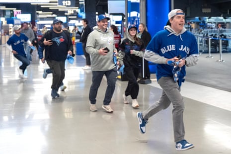 Blue Jays fans rush to gain a vantage point as gates open at the Rogers Centre before Game 7.