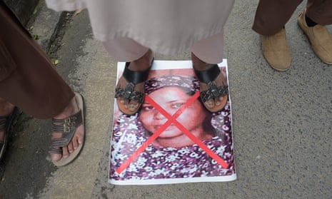 A Pakistani supporter of hardline religious party the ASWJ stands on an image of Asia Bibi during a protest rally on 2 November
