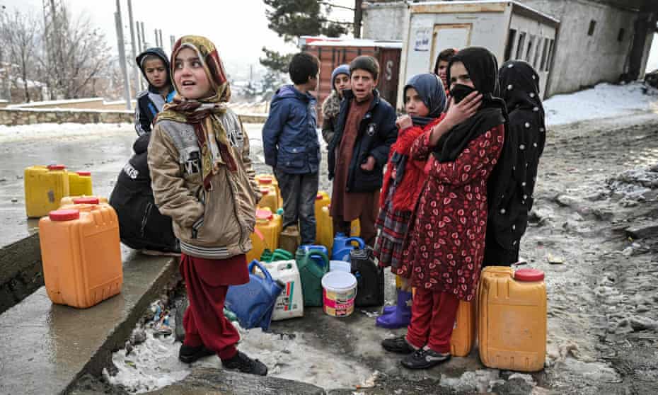 Children in Kabul wait to fill jerry cans with water.