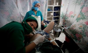A midwife student listens to the heartbeat of a baby in the delivery room as a woman prepares to give birth at the Bamyan provincial hospital in Afghanistan, 2009