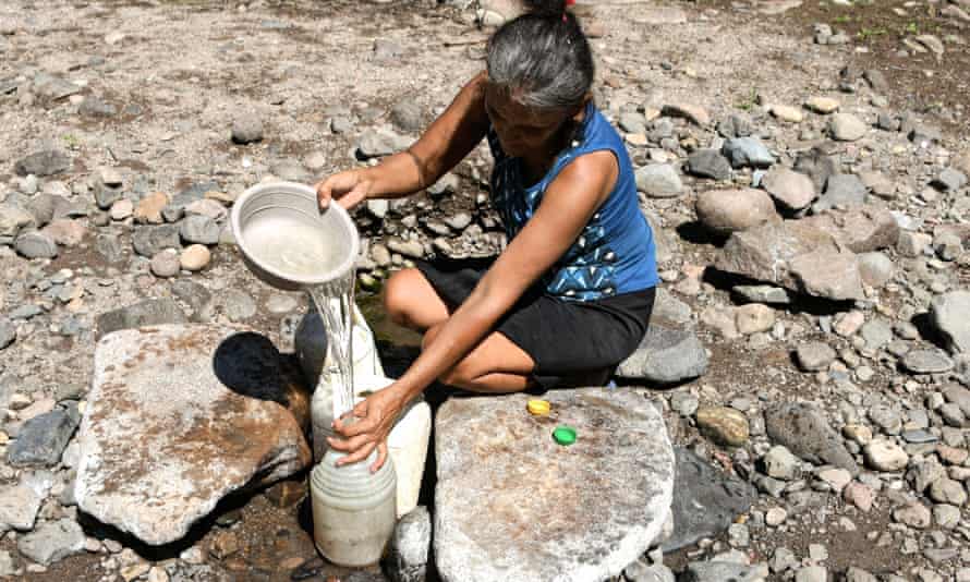 Maria Gutierrez, collects water from a hole in the sand, at the ‘El Salto’ stream, whose bed is almost completely dry, in San Francisco de Coray municipality, 100km south of Tegucigalpa, a rural community under emergency due to severe drought, on 10 September.