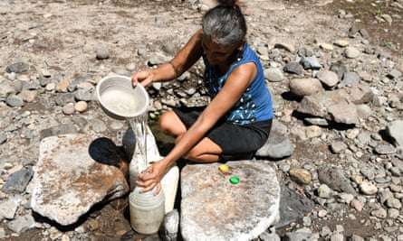 Maria Gutierrez, collects water from a hole in the sand, at the ‘El Salto’ stream, whose bed is almost completely dry, in San Francisco de Coray municipality, 100km south of Tegucigalpa, a rural community under emergency due to severe drought, on 10 September.