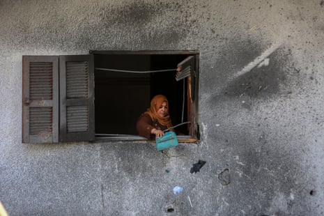 A woman is seen in a destroyed building belonging to the An-Nahal family in Rafah.