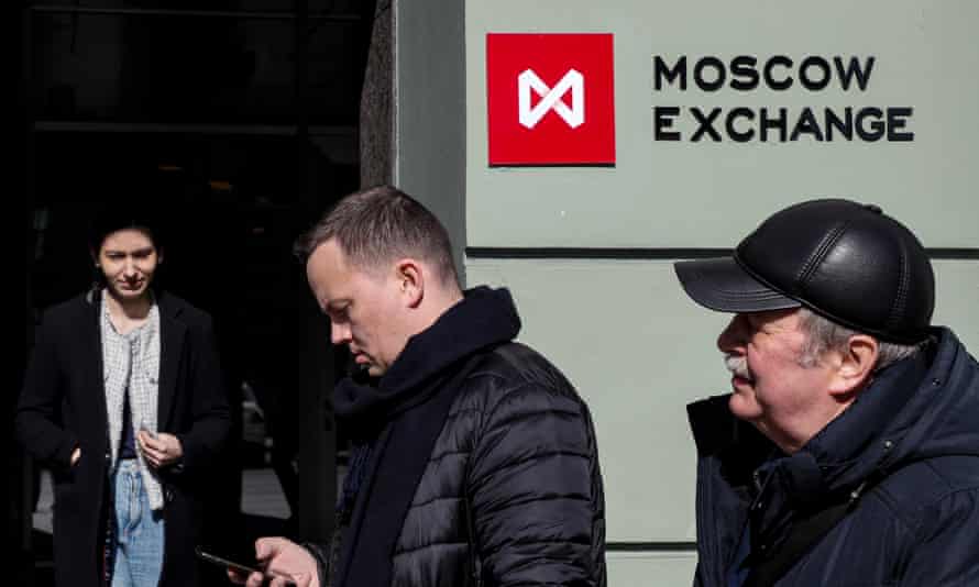 People walk near a building with a board with the logo of the Moscow Exchange in downtown Moscow, Russia, on 24 March 2022.