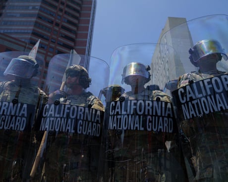 Members of the California National Guard stand behind shields Members of the California National Guard stand behind shields