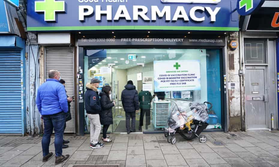 People wait in line to receive a Covid booster in north London, December 2021.