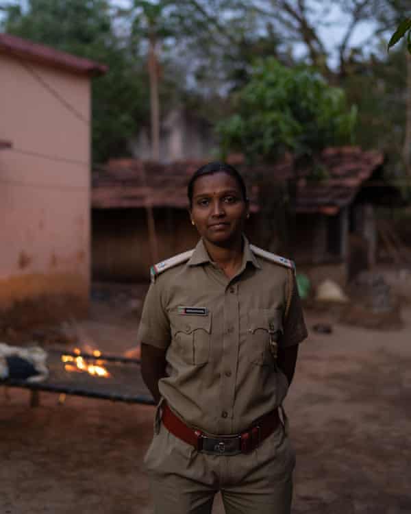 Snehalata Dhal standing in front of small fire.