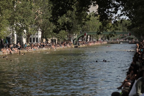 People swim at Canal Saint-Martin to cool off during heatwave in Paris, France.