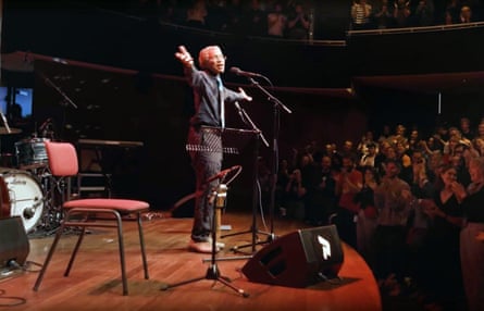 The singer/songwriter Beverly Glen-Copeland is on stage with his arms outstretched to his audience
