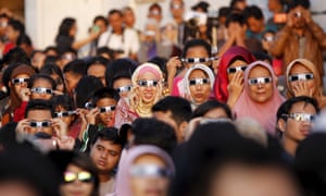 People watch a solar eclipse outside the planetarium in Jakarta.