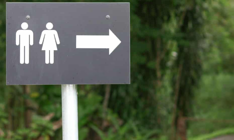 A sign with a male and female symbol showing the way to the restroom