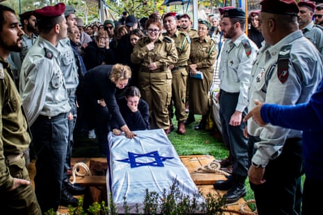Family members weep as they touch the coffin of Maj Ilay Levy during his funeral ceremony at the Tel Aviv's military cemetery. Major, Ilay Levi, 24, was killed in battle in southern Gaza Strip