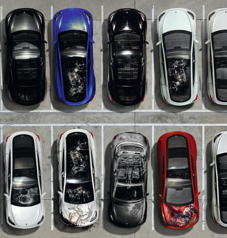 A closeup of 10 cars parked in neighbouring bays in a 5x2 formation. Most of them are smashed in some way