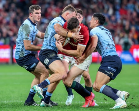 The Waratahs defence wraps up Blair Kinghorn.