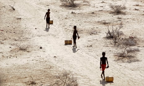 Young boys pull containers of water as they return to their huts from a well in the village of Ntabasi in Kenya