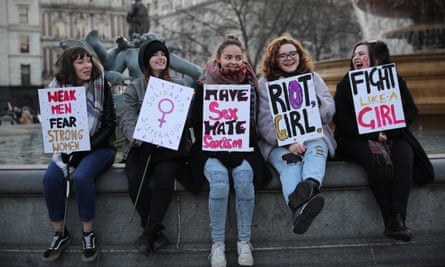 Signs of the times: protesters on the Women’s March in London take a breather.