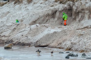 Zimbabweans work on a mined beach in Stanley