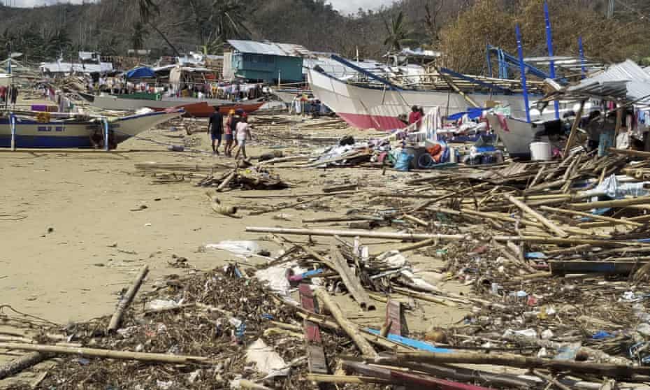 Resident walks past debris from damaged homes in the coastal village of Roxas, in western Palawan province.