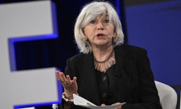 Laurence Tubiana gestures while speaking from a chair on a stage
