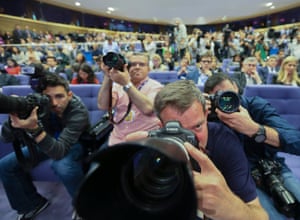 Photojournalists aim their cameras at Jean-Claude Juncker during his speech