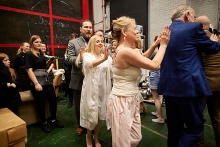 Cast members pat each other’s backs backstage